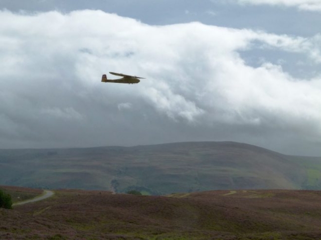 Radio control glider flying over Welsh hills